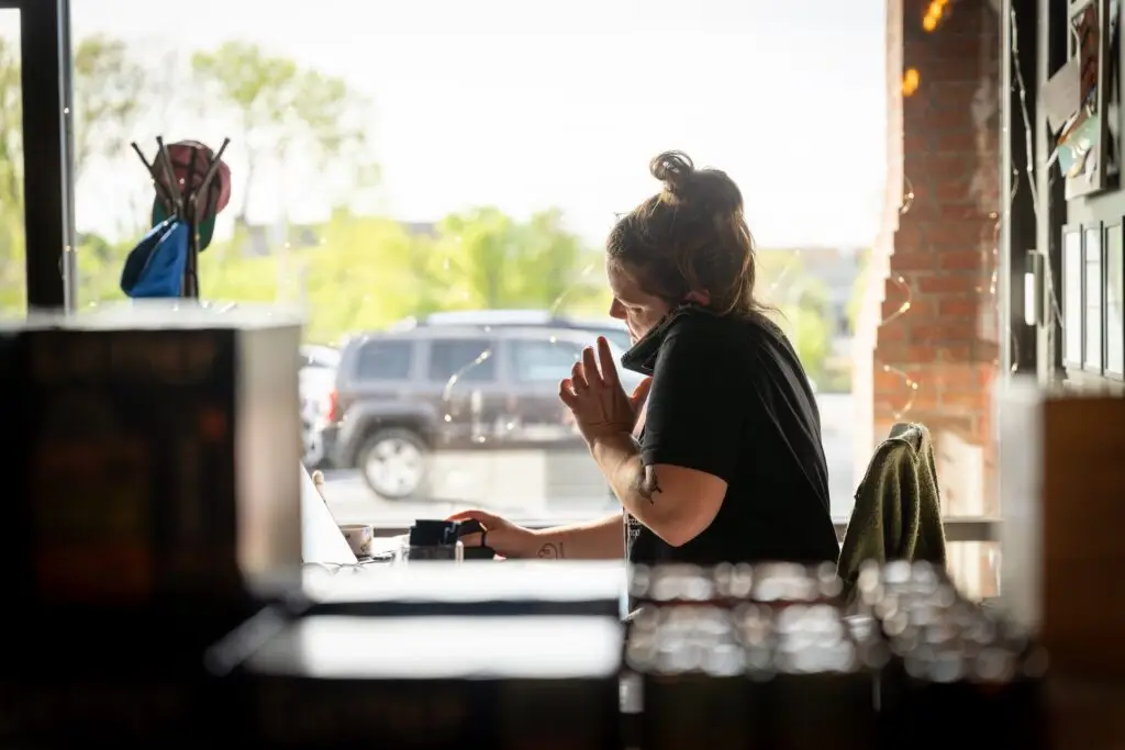 Business owners talking on phone and typing information into laptop computer