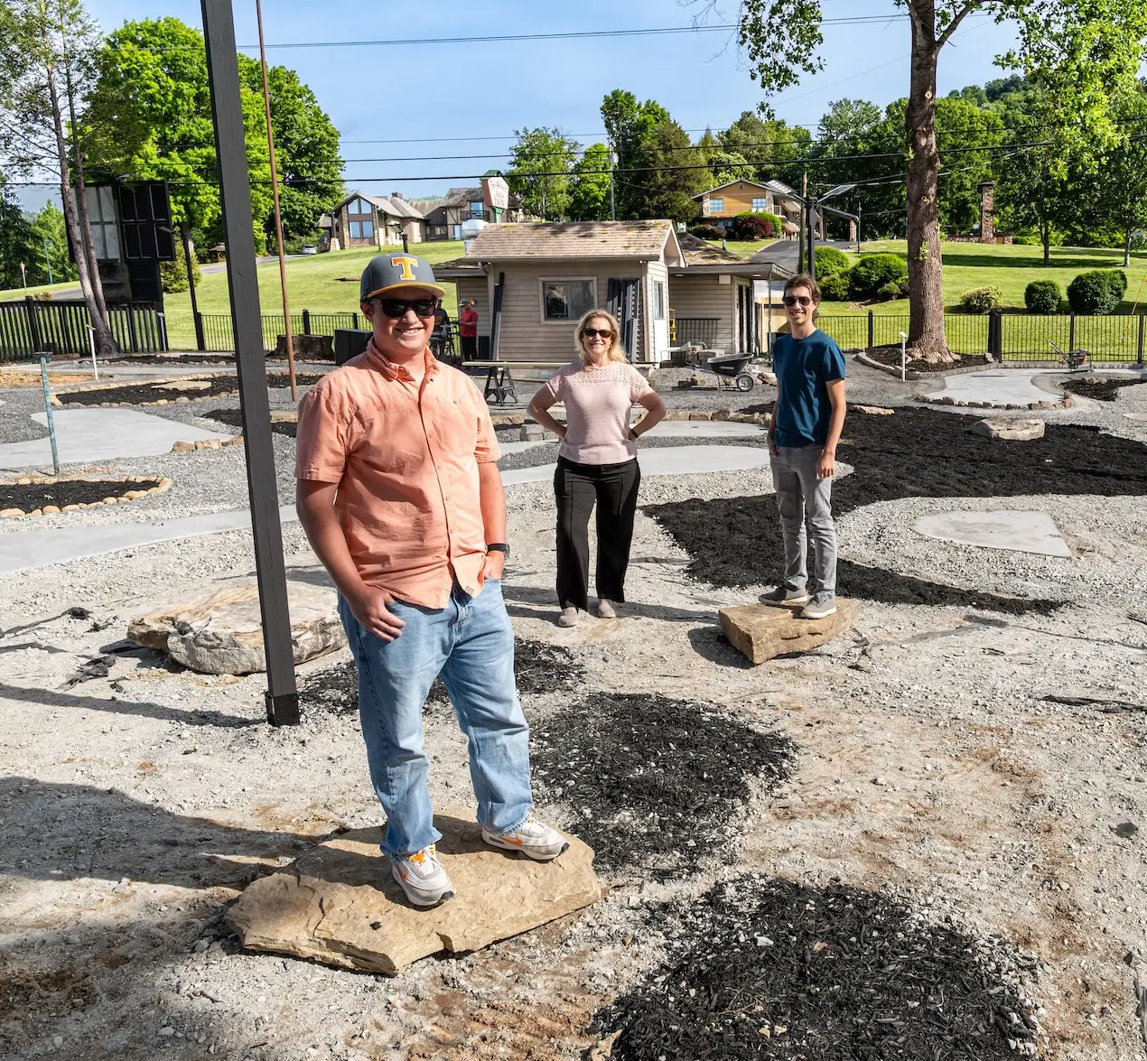 Three people standing in the middle of a mini golf course
