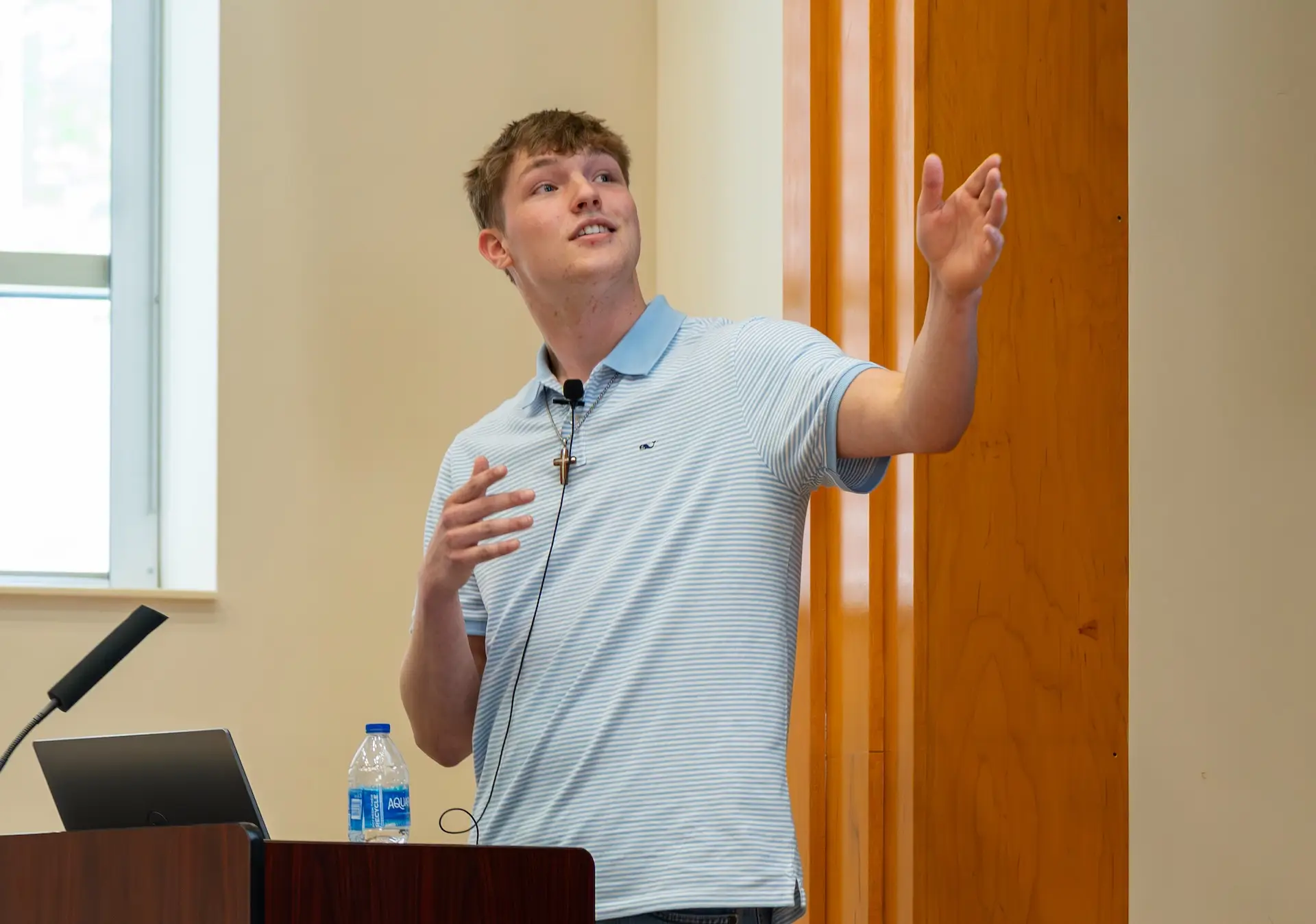 young man points toward screen while presenting